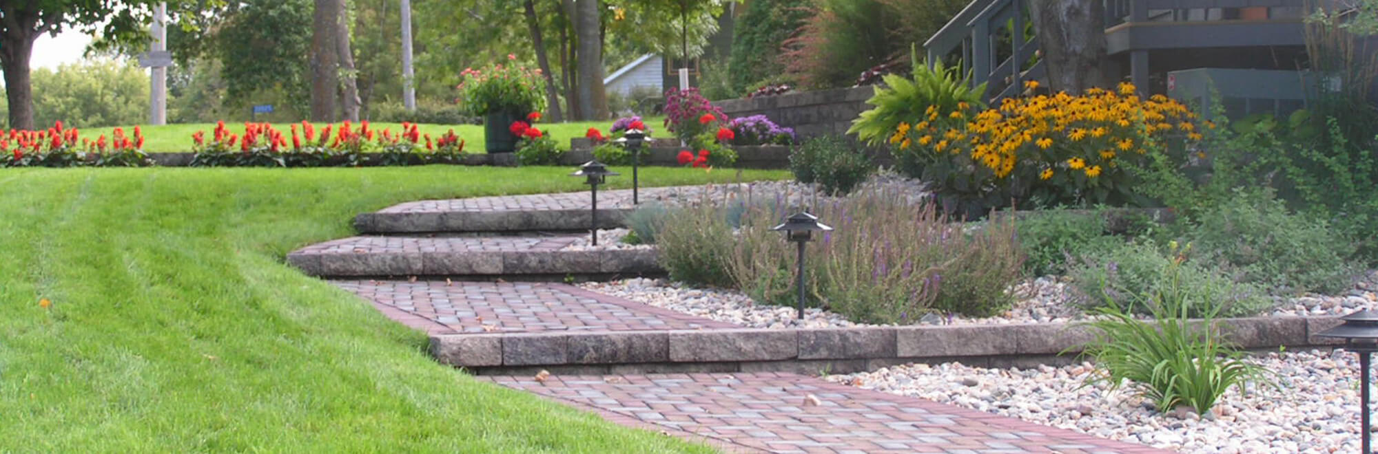 Home landscape complete with softscape flower gardens and stone paver steps